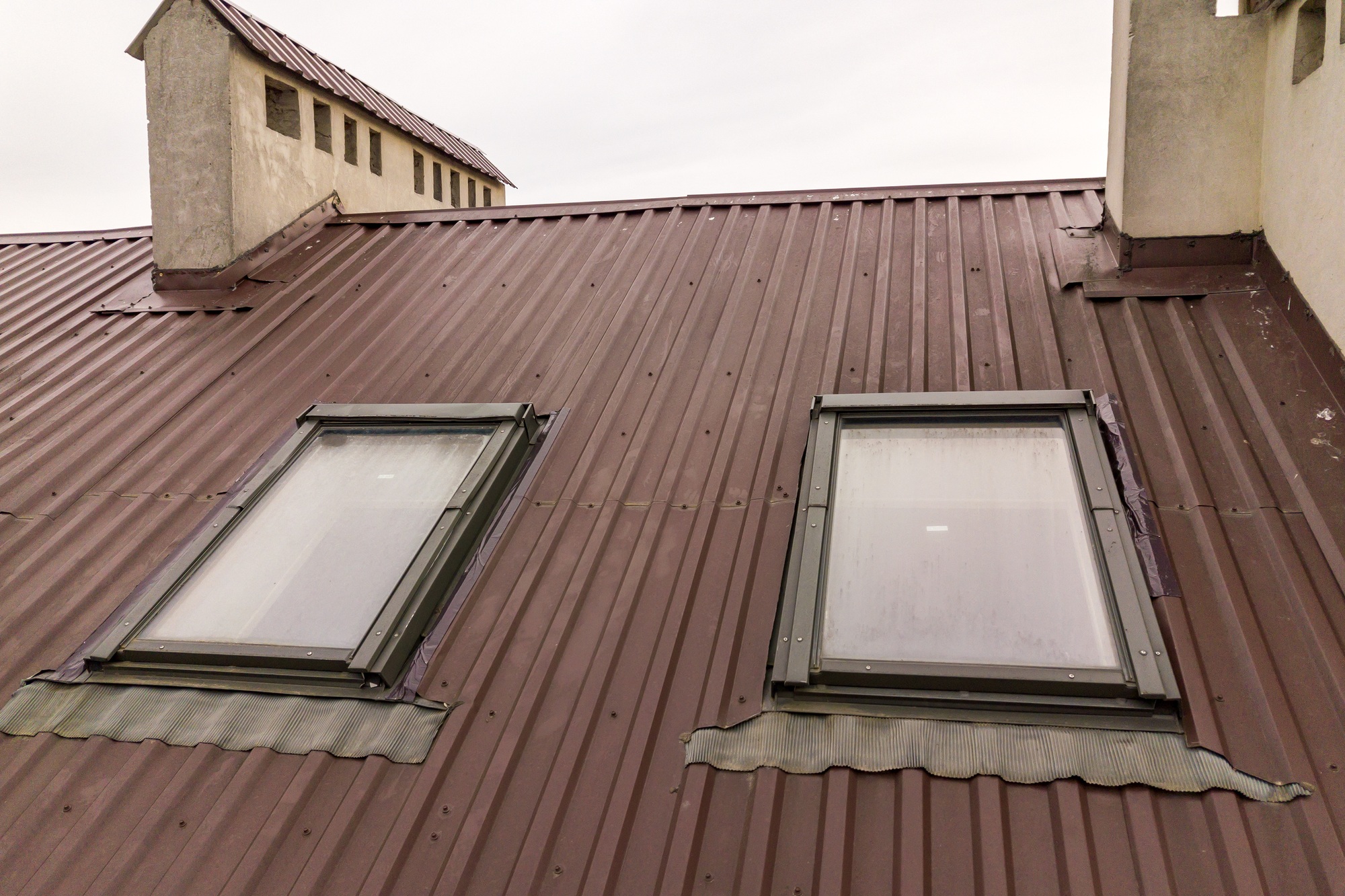 Roof of a house made from metal sheets with attic windows